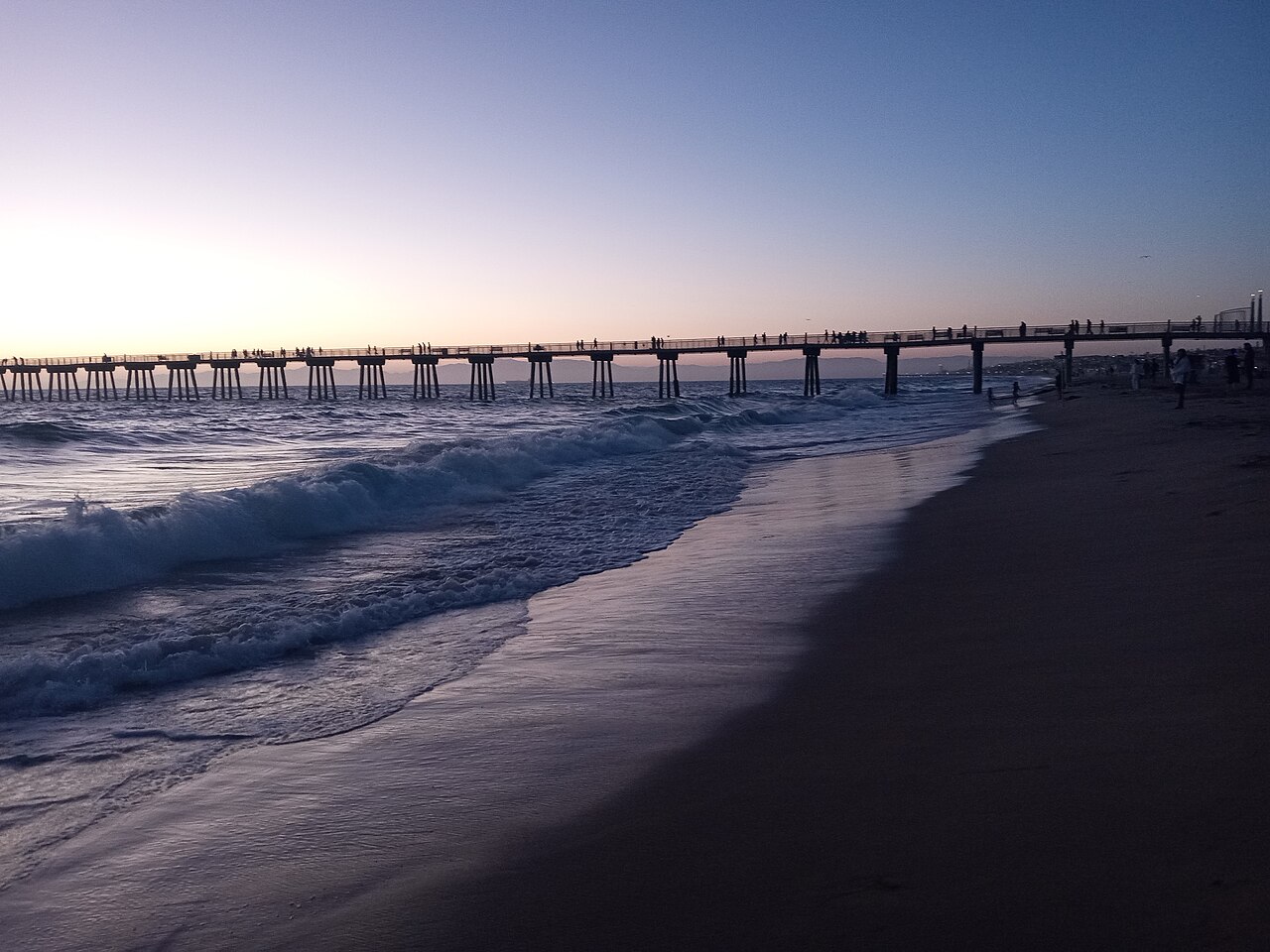 The real Hermosa Beach Pier and ocean waves at sunset
