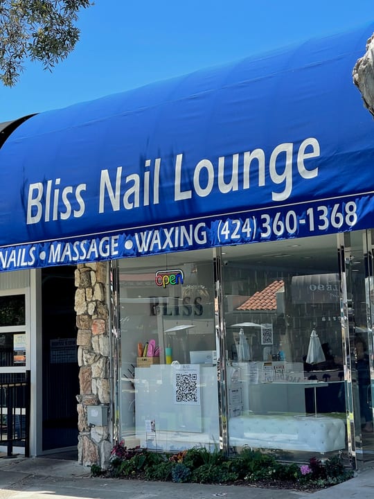 Bliss Nail Lounge on Catalina Avenue in Redondo Beach, with its blue awning and a white tufted bench inside the window