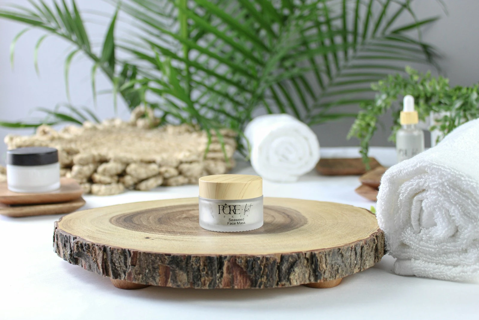 Skincare and folded towels on a wooden surface