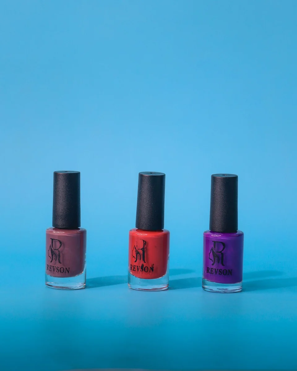 Bright nail polish bottles arranged on a blue background.