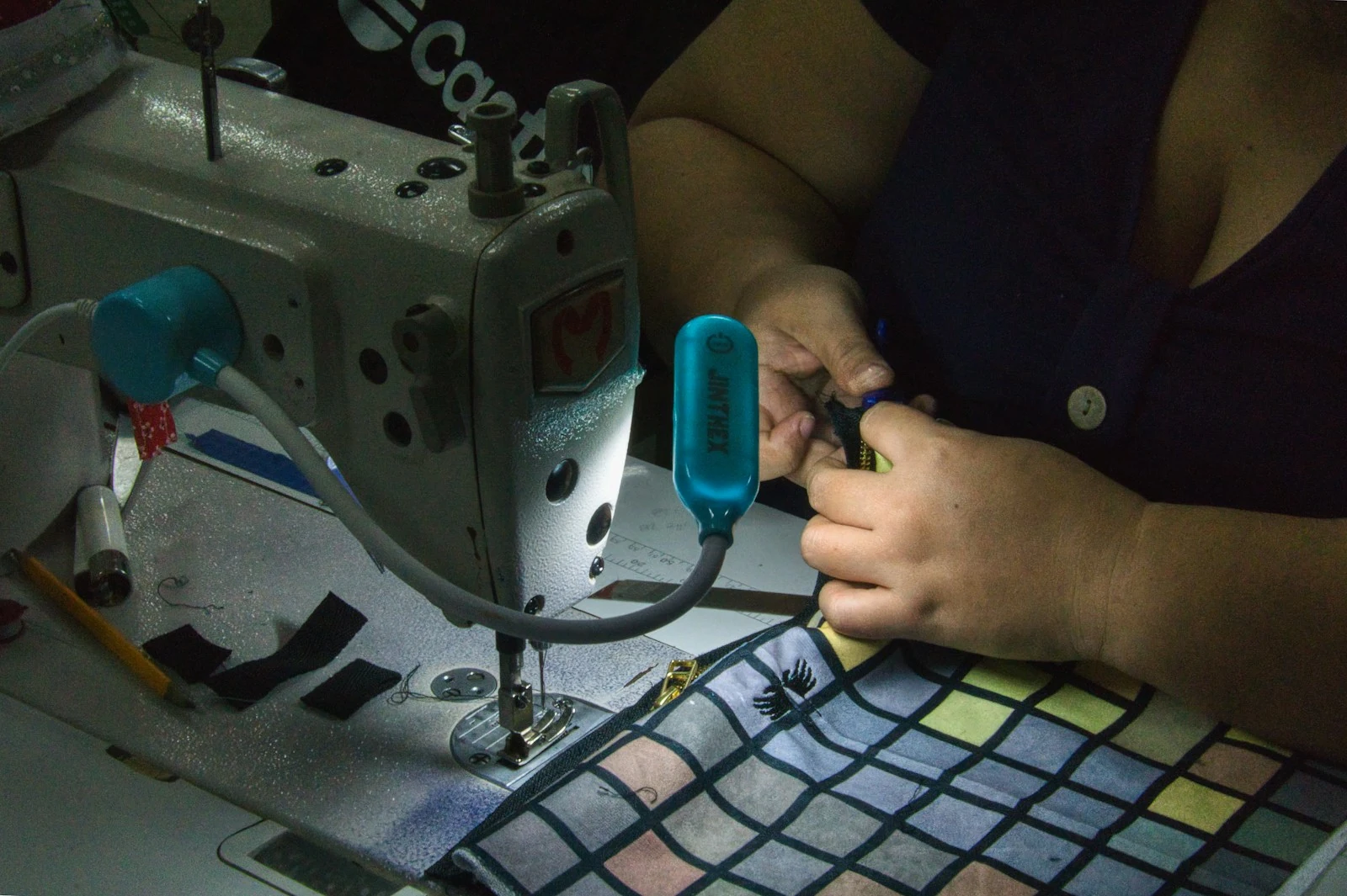Hands guiding fabric through a sewing machine