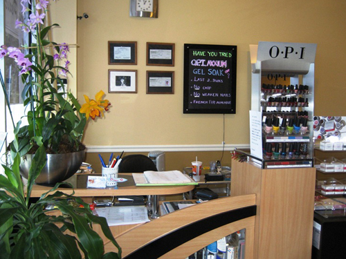Reception desk, orchids and nail polish displays inside Lovely Nails & Day Spa