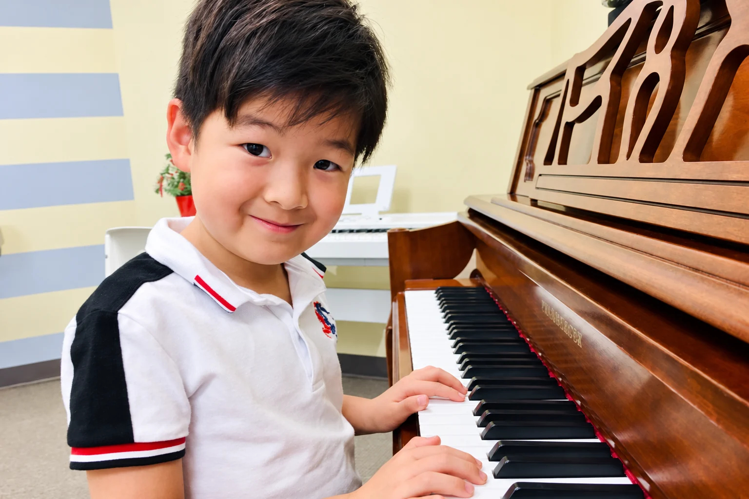 A young student enjoying time at an upright piano