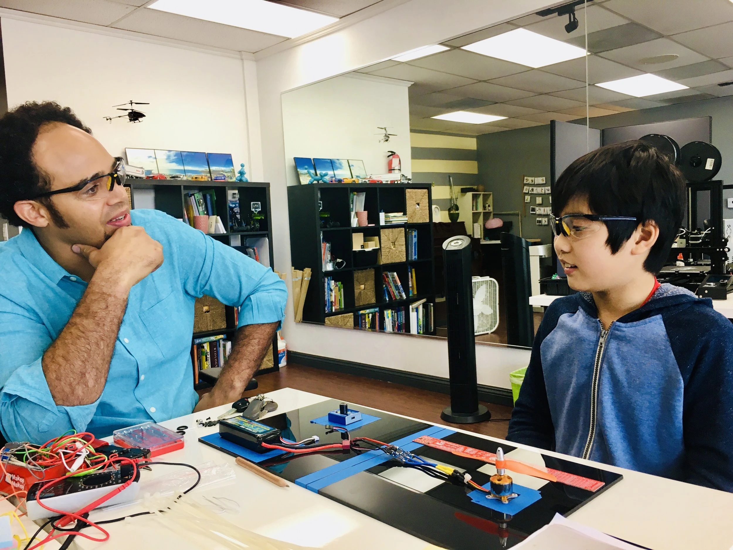 A student and educator examining an electronics project.