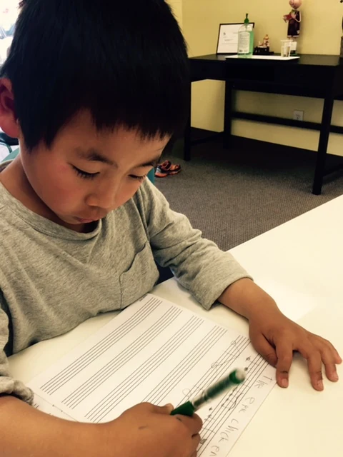 A student writing music notation.