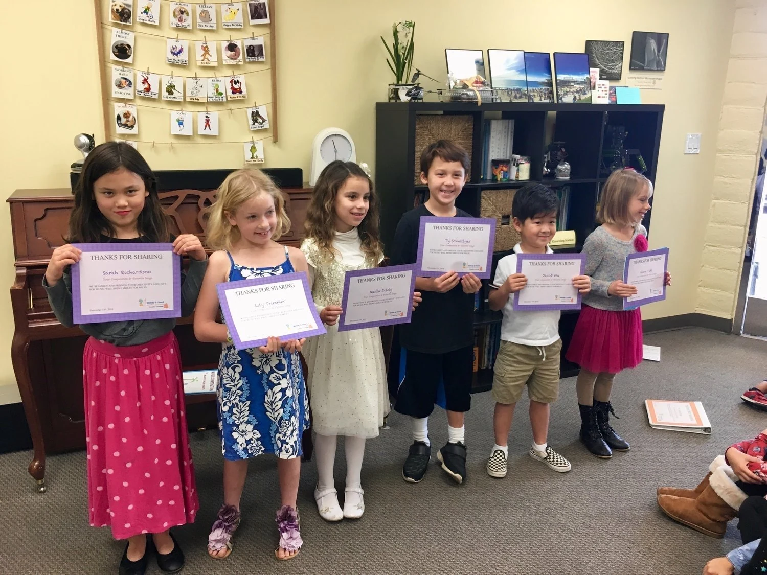 Students holding music certificates.