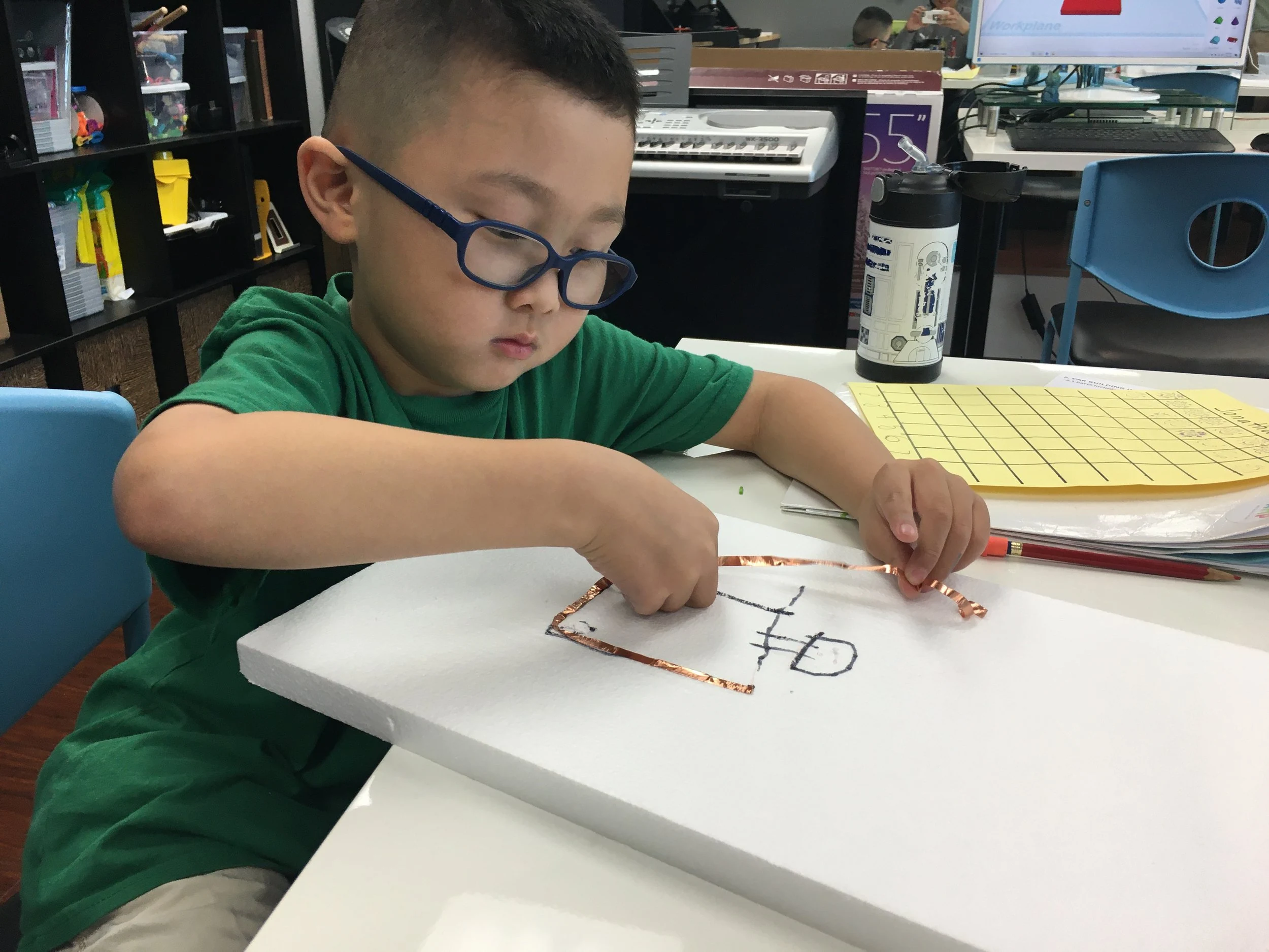 A student drawing a technical sketch.