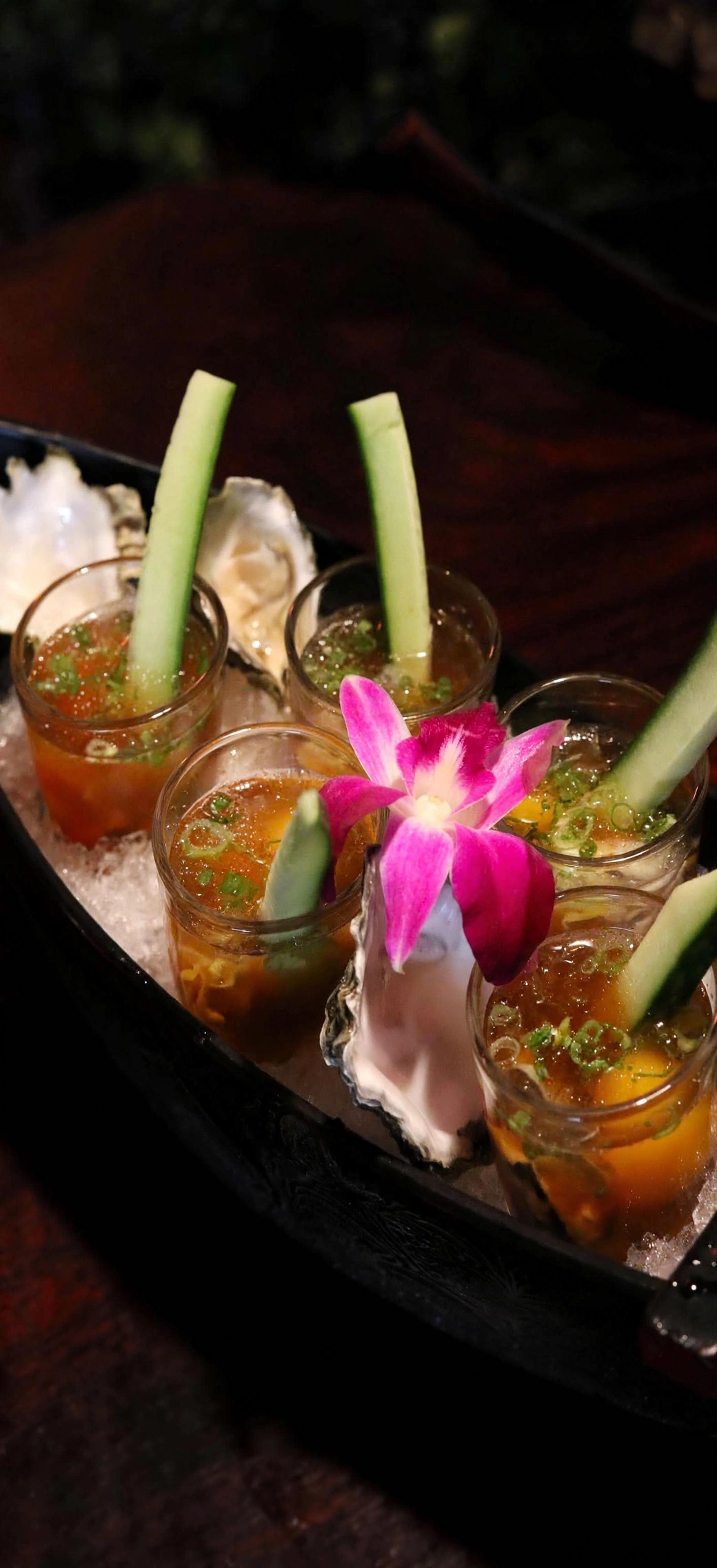 Oyster presentation with cucumber and orchid garnish