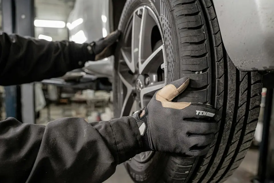 Albertos Polishing · Gloved technician fitting a vehicle wheel — illustrative stock photograph 2