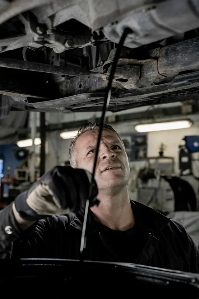 Albertos Polishing · Mechanic inspecting the underside of a raised car — illustrative stock photograph 3