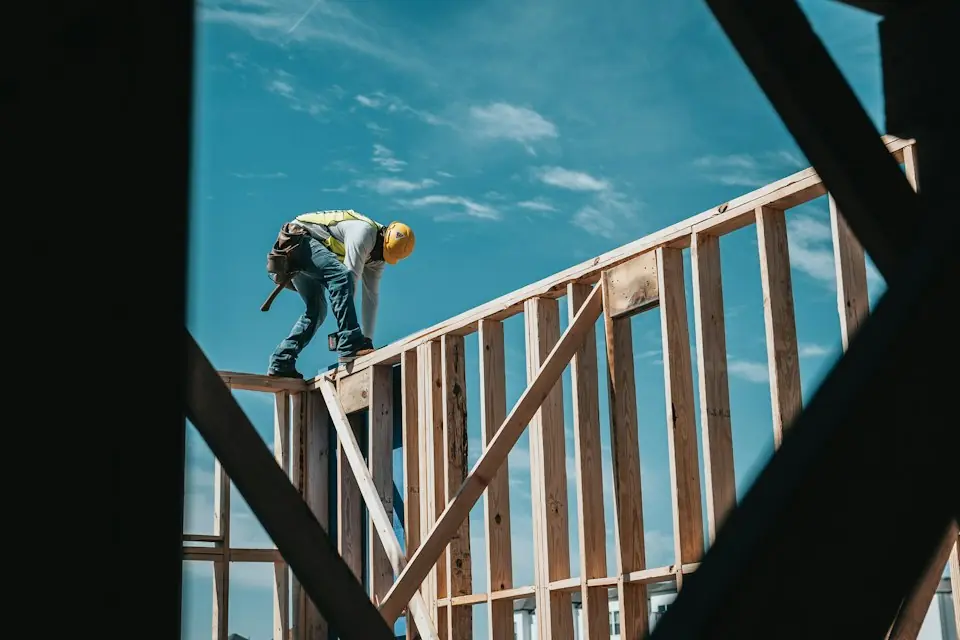 Home improvement · Carpenter working on timber wall framing — illustrative stock photograph