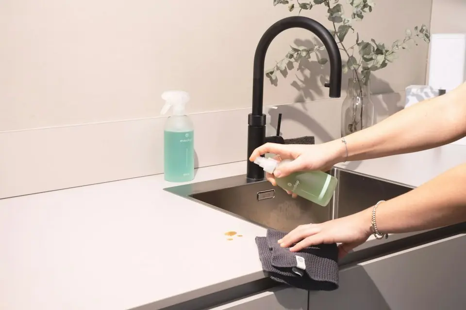 Boardwalk Cleaners · Person wiping a kitchen worktop — illustrative stock photograph 3