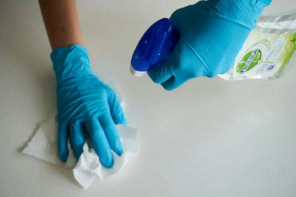 Boardwalk Cleaners · Gloved hands wiping a surface with a cloth and spray — illustrative stock photograph 2